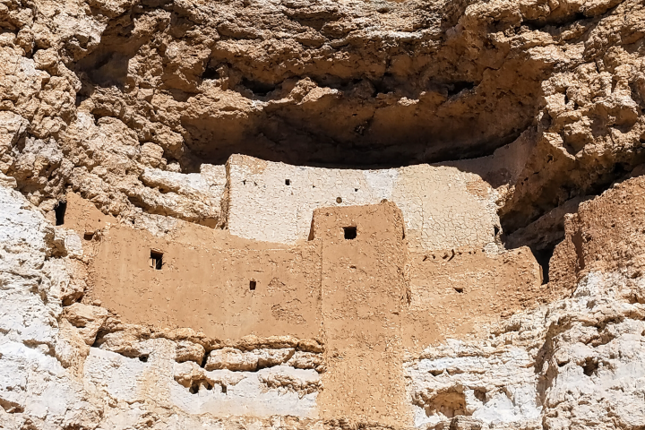 Ancient cliff dwelling built into a rock face, featuring small windows.
