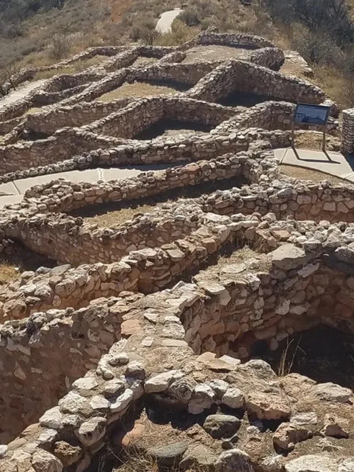 Aerial view of ancient stone ruins on a hillside path.