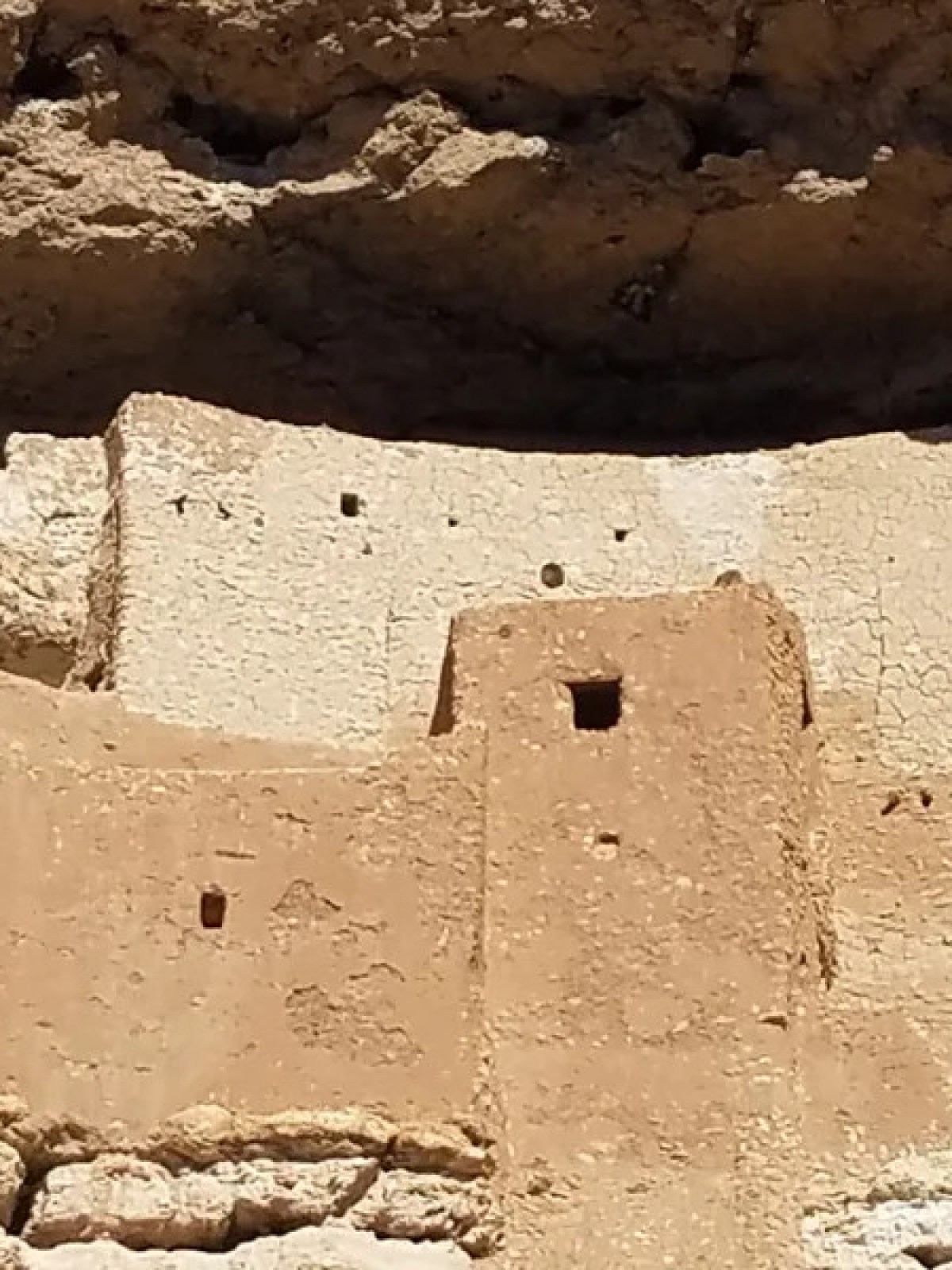 Ancient cliff dwelling built into a rocky cliff face.