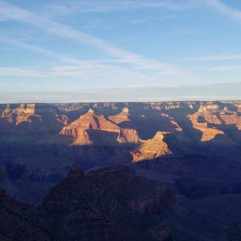 Scenic view of the Grand Canyon at sunset with shadows and vibrant colors.